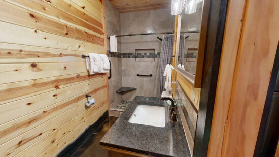 Rustic bathroom with wooden walls and modern fixtures.