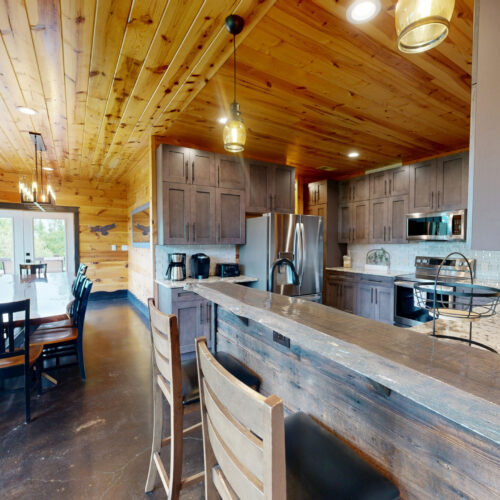 Rustic kitchen with wooden ceiling and modern appliances.