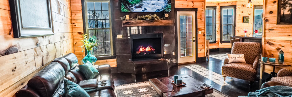Cozy living room with leather furniture, fireplace, and wood interior.