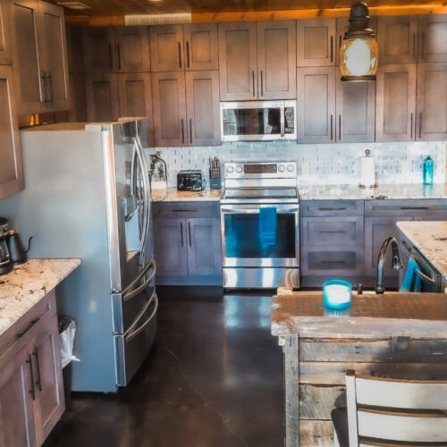 Rustic kitchen with modern appliances and wooden cabinetry.