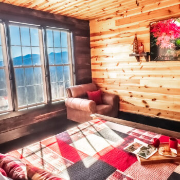 Cozy wooden cabin corner with a window seat and warm sunlight.