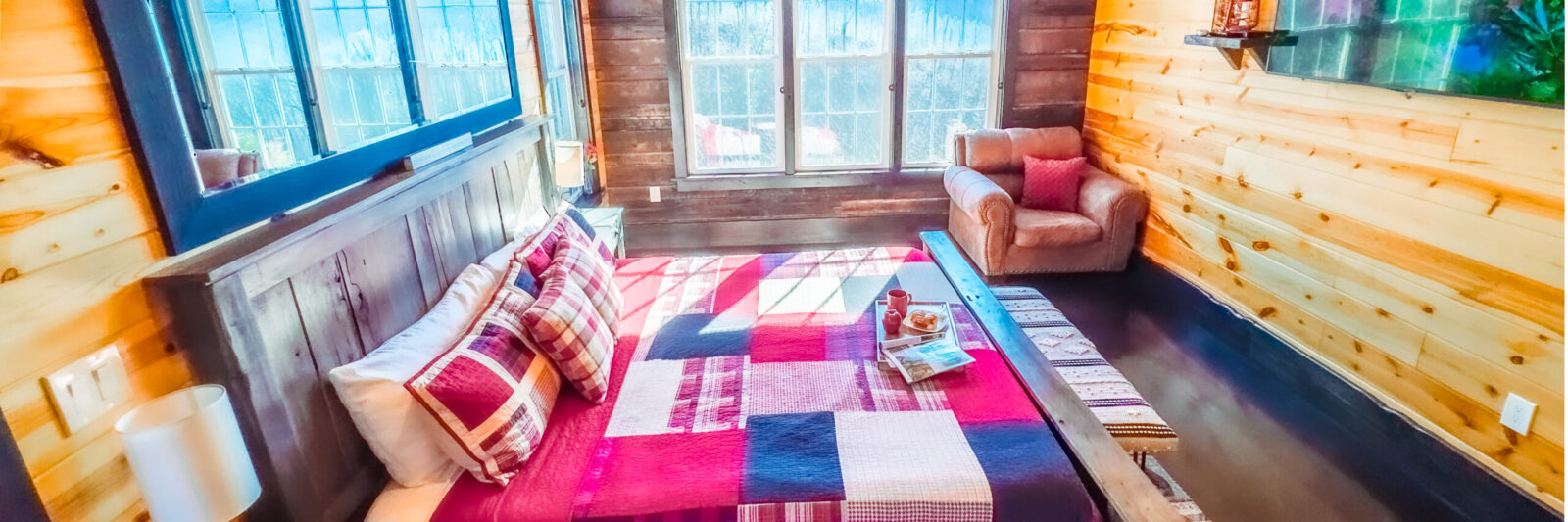 Cozy bedroom with plaid bedding and warm wooden walls.