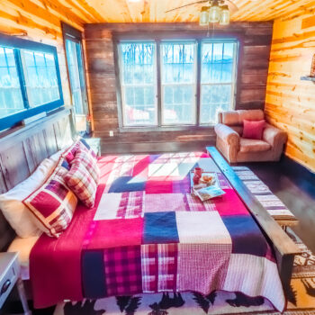 Cozy bedroom with plaid bedding and warm wooden walls.