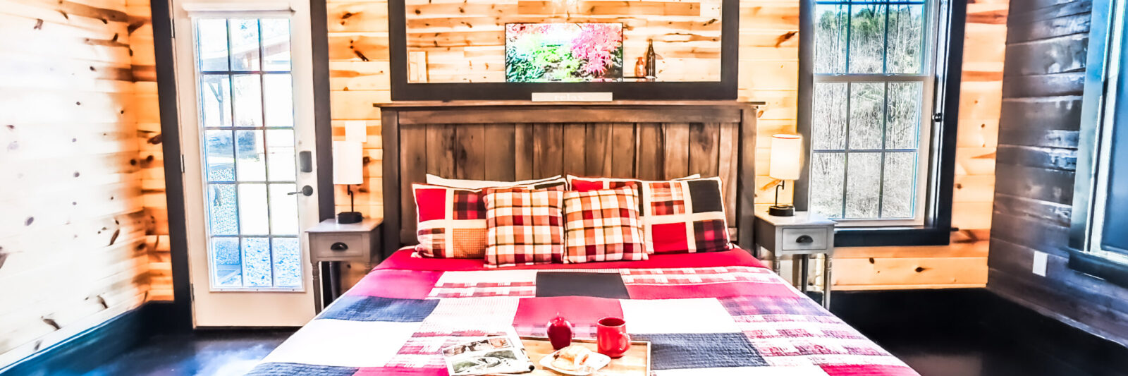 Cozy rustic bedroom with plaid bedding and warm wooden walls.