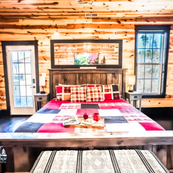 Cozy rustic bedroom with plaid bedding and warm wooden walls.