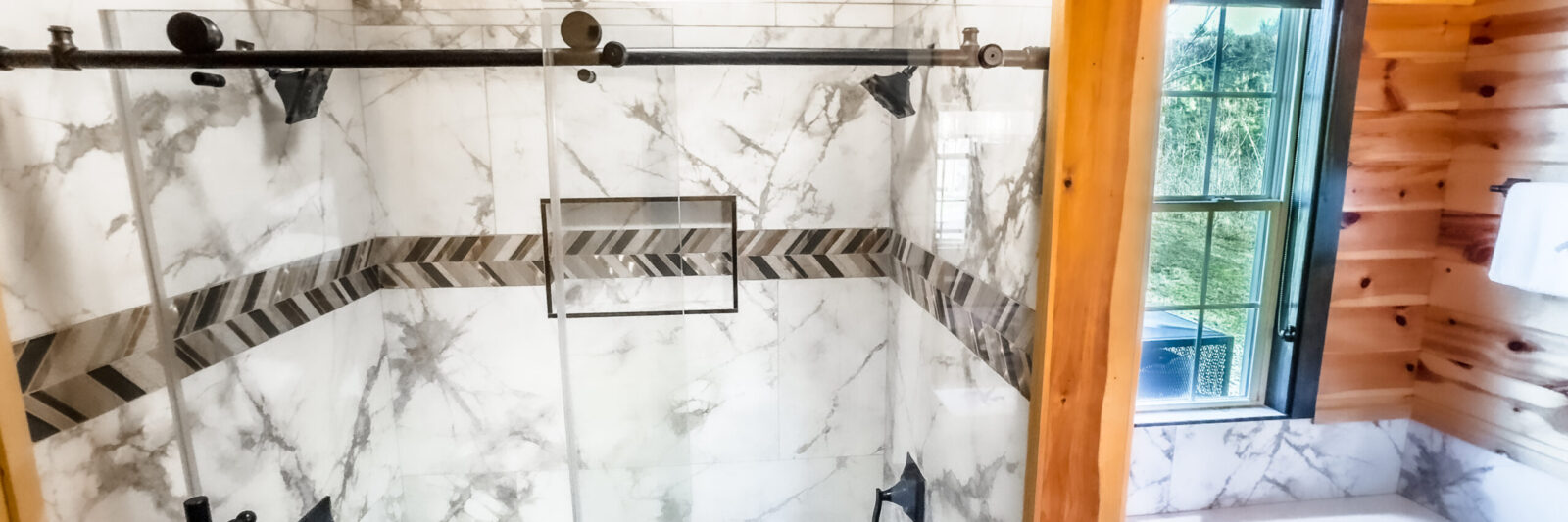 Modern shower with marble tiles and pebble floor.
