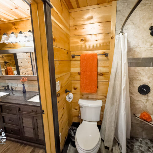 Cozy wooden bathroom with modern fixtures and a stone accent wall.