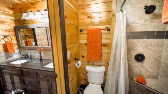 Cozy wooden bathroom with modern fixtures and a stone accent wall.