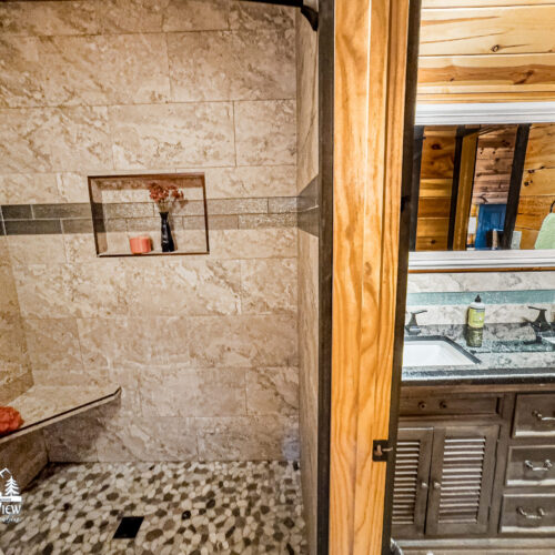 Rustic bathroom with stone walls and wooden accents.