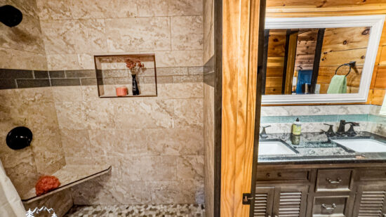 Rustic bathroom with stone walls and wooden accents.