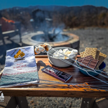 Outdoor s'mores setup with marshmallows, chocolate, and graham crackers.