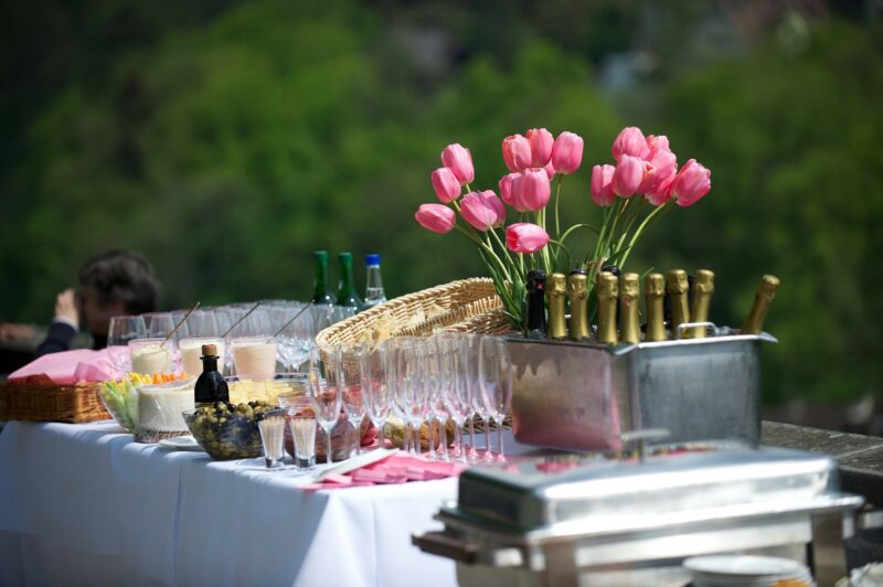 Elegant outdoor table setting with pink tulips and glasses.