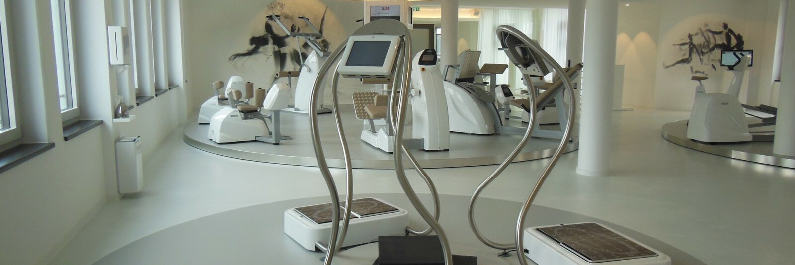 Modern gym with advanced exercise machines in a bright room.